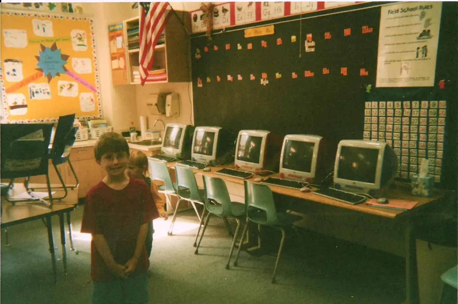 Young James in a classroom lined with iMacs